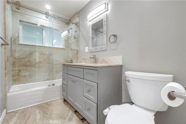 full bathroom featuring vanity, tiled shower / bath combo, and toilet