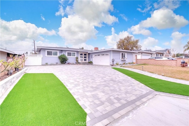 ranch-style home with a garage and a front lawn