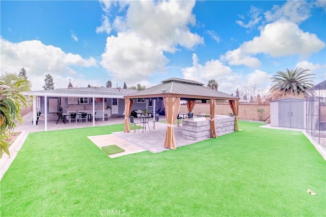 back of property with a gazebo, a patio area, a shed, and a lawn