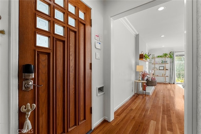 entrance foyer featuring ornamental molding and light wood-type flooring