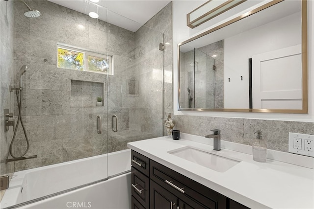 bathroom with vanity, bath / shower combo with glass door, and decorative backsplash