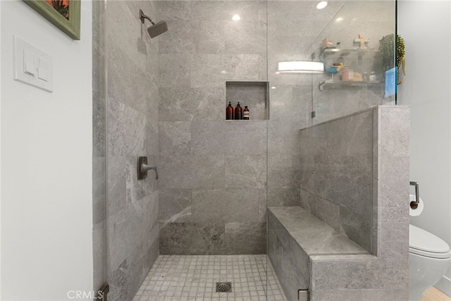 bathroom featuring toilet and tiled shower