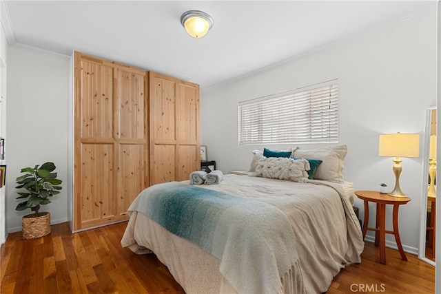 bedroom featuring dark hardwood / wood-style flooring and crown molding