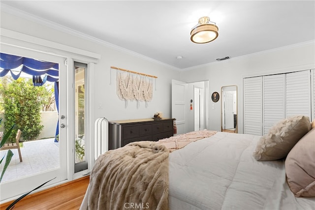 bedroom with access to exterior, crown molding, a closet, and light wood-type flooring