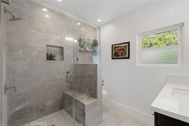 bathroom with vanity, toilet, and a shower with door