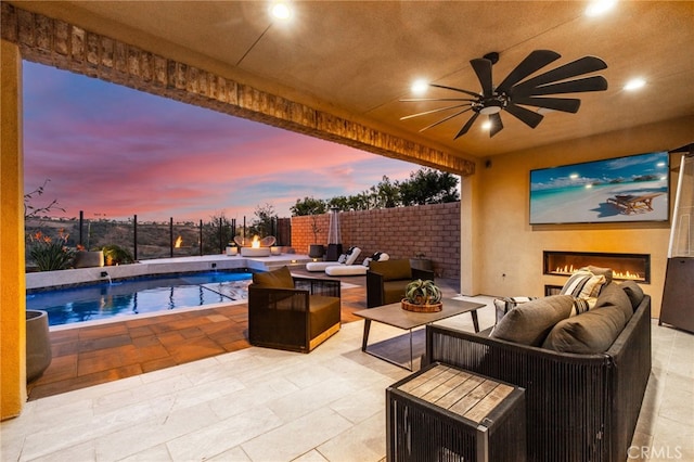 view of patio / terrace with a fenced in pool, an outdoor living space with a fireplace, and ceiling fan