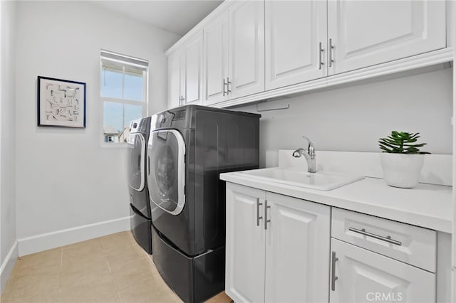 washroom featuring sink, light tile patterned floors, cabinets, and washer and dryer