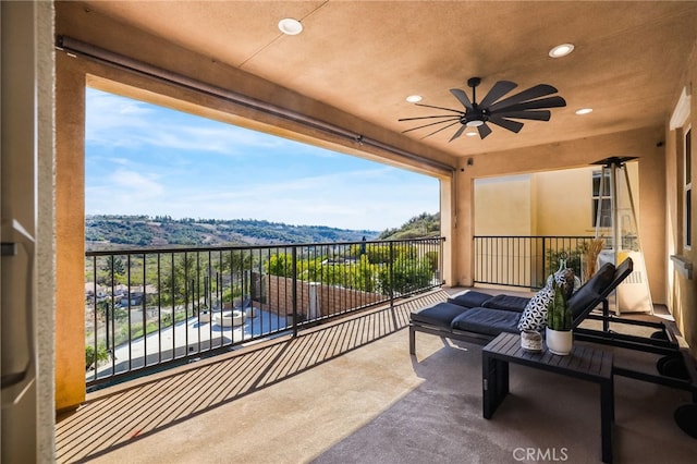 balcony featuring a mountain view and ceiling fan