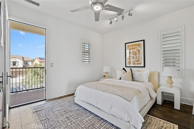 bedroom with multiple windows, ceiling fan, access to exterior, and dark hardwood / wood-style flooring