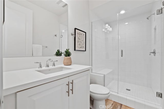 bathroom featuring vanity, hardwood / wood-style floors, an enclosed shower, and toilet