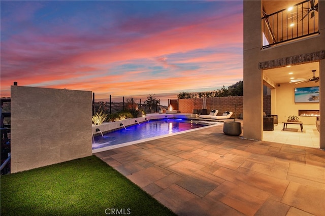 view of swimming pool featuring pool water feature, ceiling fan, and a patio area