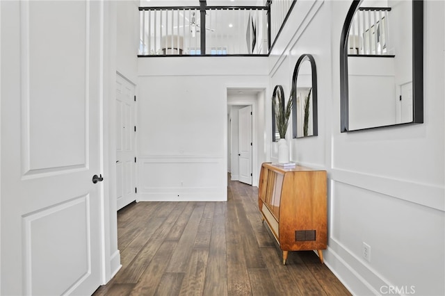 corridor featuring dark hardwood / wood-style floors and a high ceiling