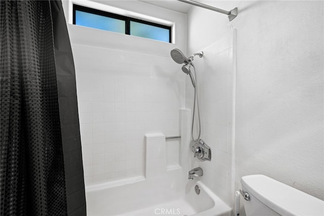 bathroom featuring shower / tub combo and toilet