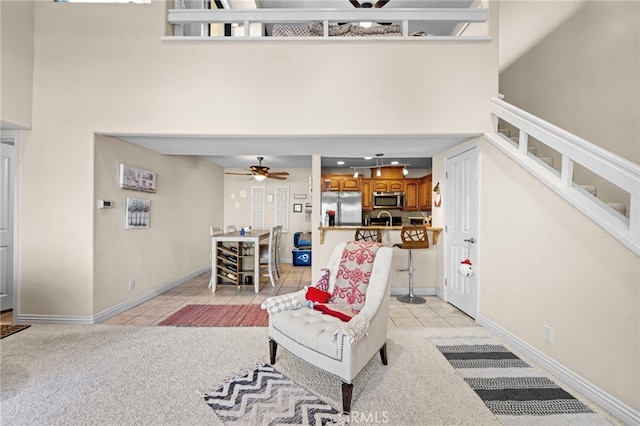 tiled living room with a high ceiling and ceiling fan