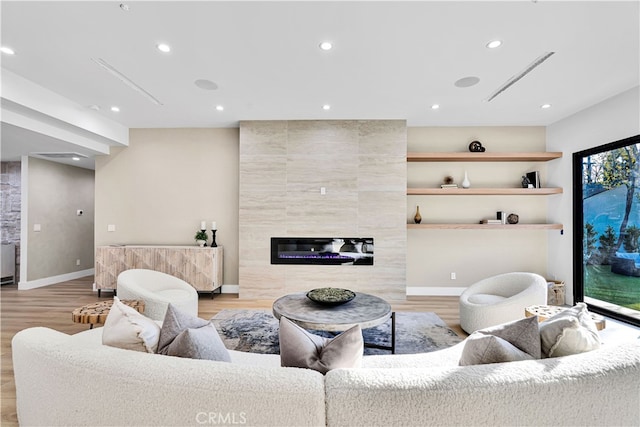 living room featuring a fireplace and light wood-type flooring