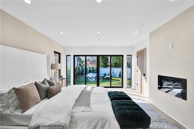 bedroom with access to exterior and light hardwood / wood-style flooring