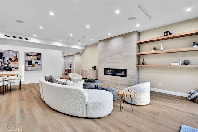 living room featuring light hardwood / wood-style floors and a tile fireplace