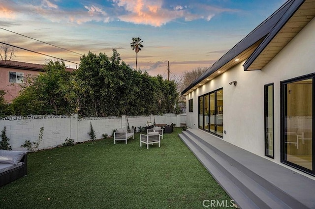 yard at dusk featuring an outdoor living space