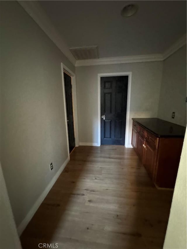 hall featuring ornamental molding and light hardwood / wood-style flooring