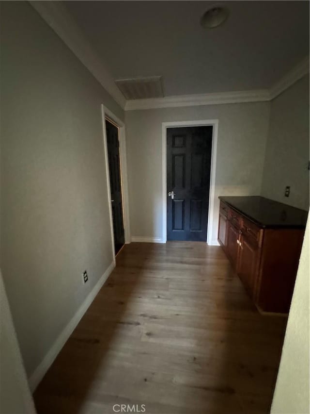 unfurnished dining area featuring light wood-style floors, baseboards, and ornamental molding