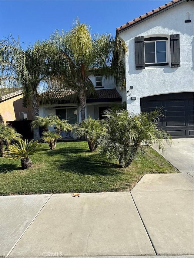 view of front of property featuring a garage and a front lawn