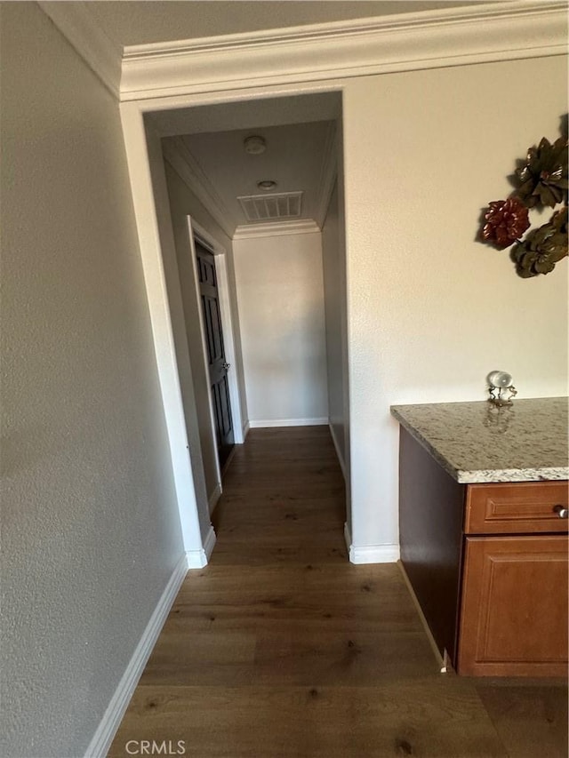 corridor with crown molding, baseboards, and dark wood finished floors