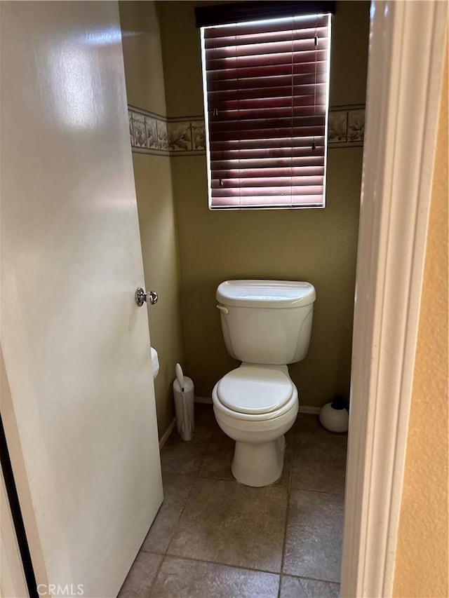bathroom with baseboards and toilet