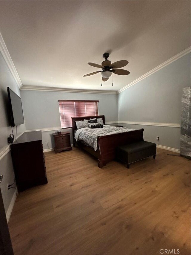bedroom featuring baseboards, ceiling fan, ornamental molding, and wood finished floors
