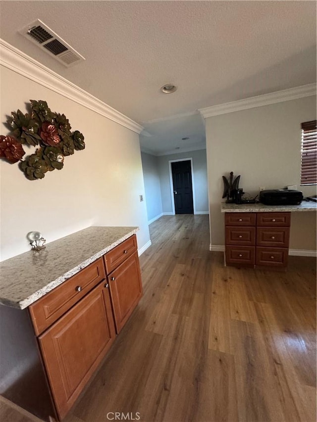 interior space with baseboards, ornamental molding, and wood finished floors