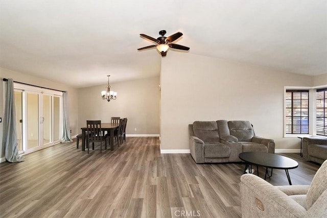 living room featuring ceiling fan with notable chandelier, lofted ceiling, and hardwood / wood-style floors