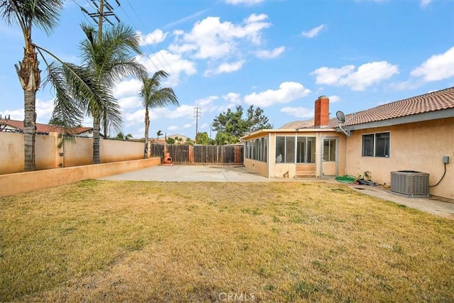 view of yard featuring a sunroom, central AC, and a patio area