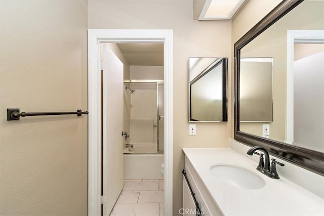 full bathroom featuring vanity, combined bath / shower with glass door, and toilet