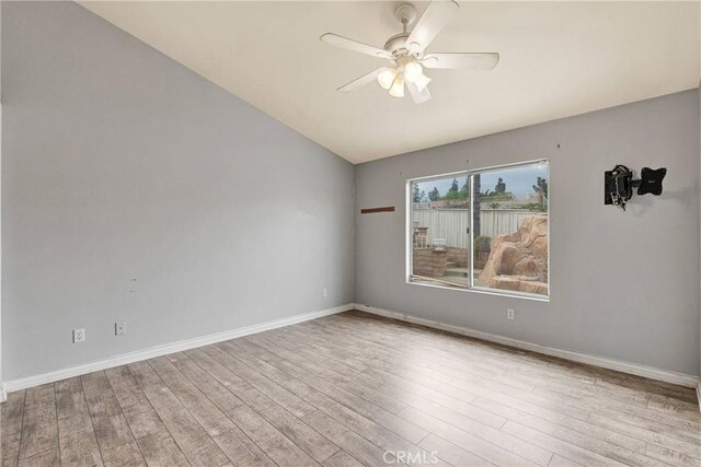 unfurnished room featuring ceiling fan, vaulted ceiling, wood finished floors, and baseboards