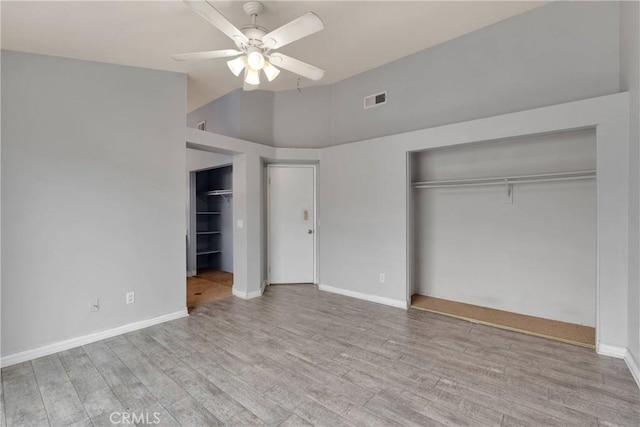 unfurnished bedroom with baseboards, a ceiling fan, wood finished floors, and visible vents