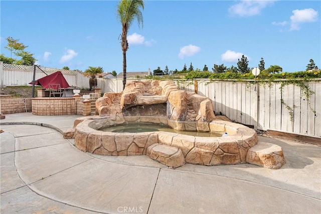 view of patio with a fenced backyard and an in ground hot tub