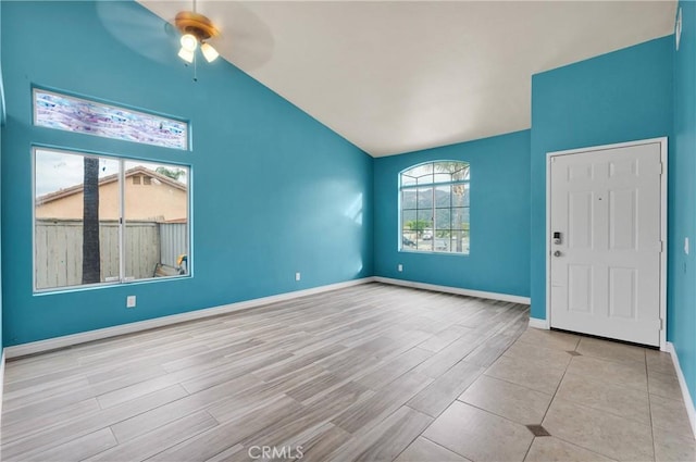 interior space featuring vaulted ceiling, wood finished floors, baseboards, and ceiling fan