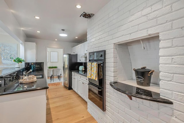 kitchen with double oven, sink, stainless steel fridge, white cabinets, and light wood-type flooring