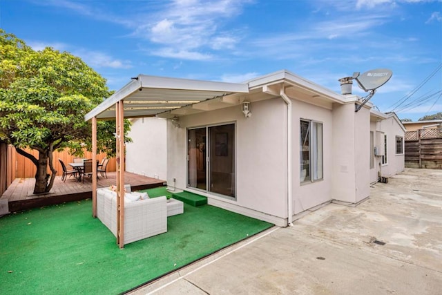 back of property featuring an outdoor living space and a patio