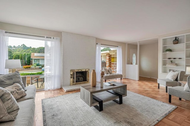 living room featuring plenty of natural light, a fireplace, and light parquet floors