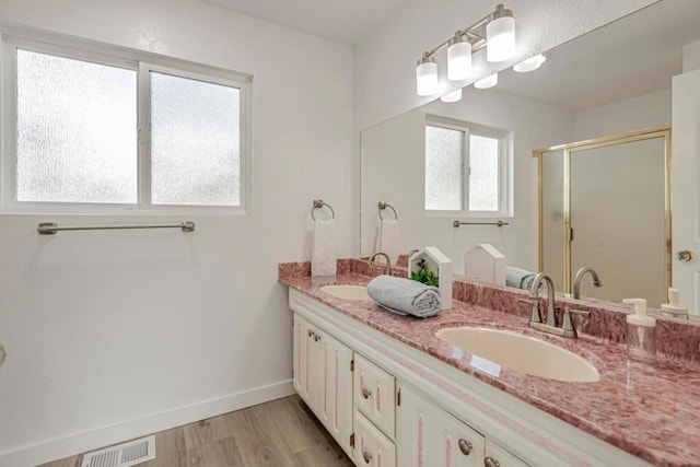 bathroom featuring vanity, an enclosed shower, and hardwood / wood-style flooring