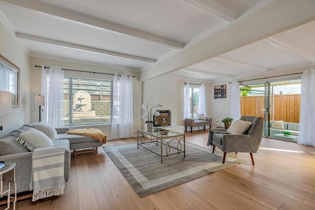 living area featuring a fireplace, beam ceiling, and wood-type flooring