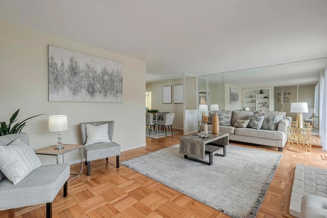 living room with built in shelves and light parquet flooring