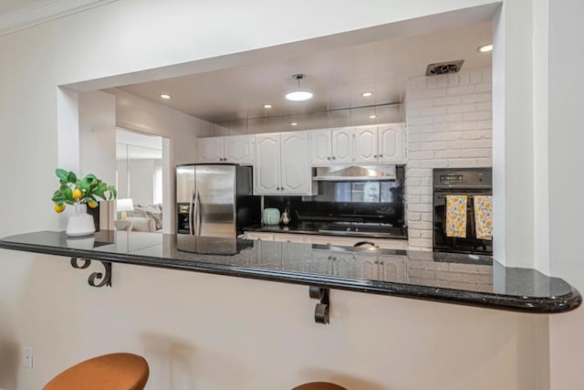 kitchen featuring white cabinetry, dark stone counters, kitchen peninsula, and black appliances