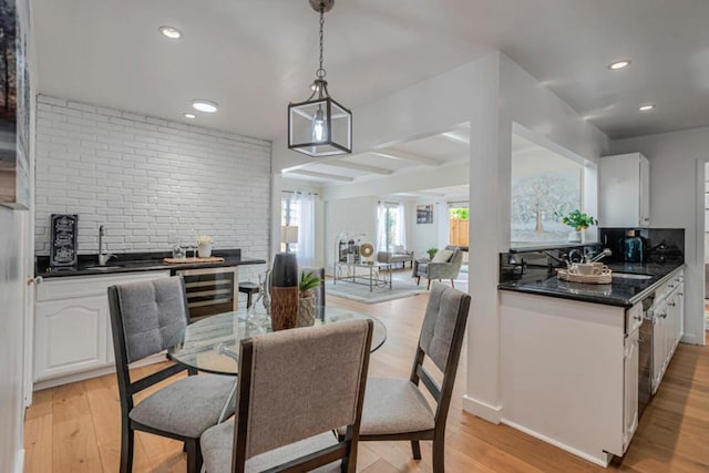 dining area with sink, wine cooler, and light wood-type flooring