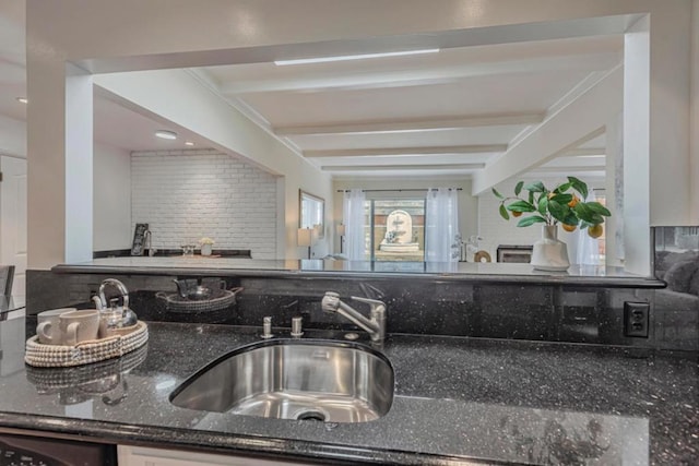 kitchen featuring beamed ceiling, tasteful backsplash, and sink