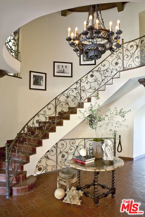 stairs with a high ceiling, tile patterned floors, and beam ceiling