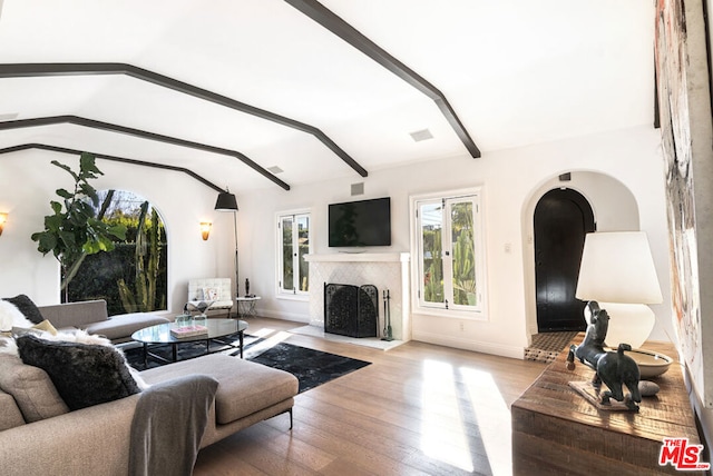 living room with vaulted ceiling with beams and light hardwood / wood-style floors