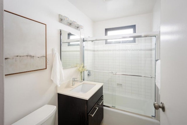 full bathroom featuring vanity, toilet, and combined bath / shower with glass door