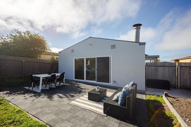 rear view of house with an outdoor living space and a patio area