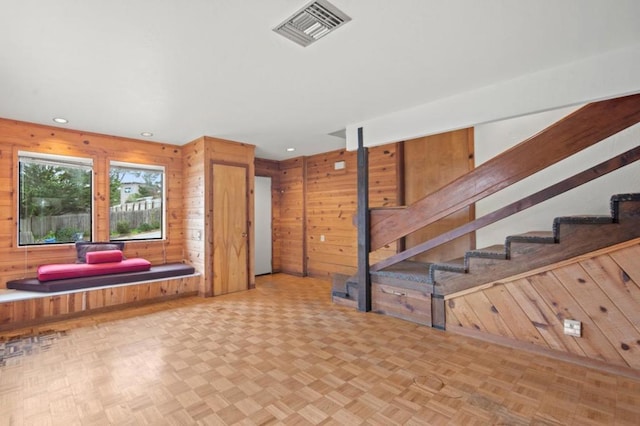 interior space with light parquet flooring and wood walls